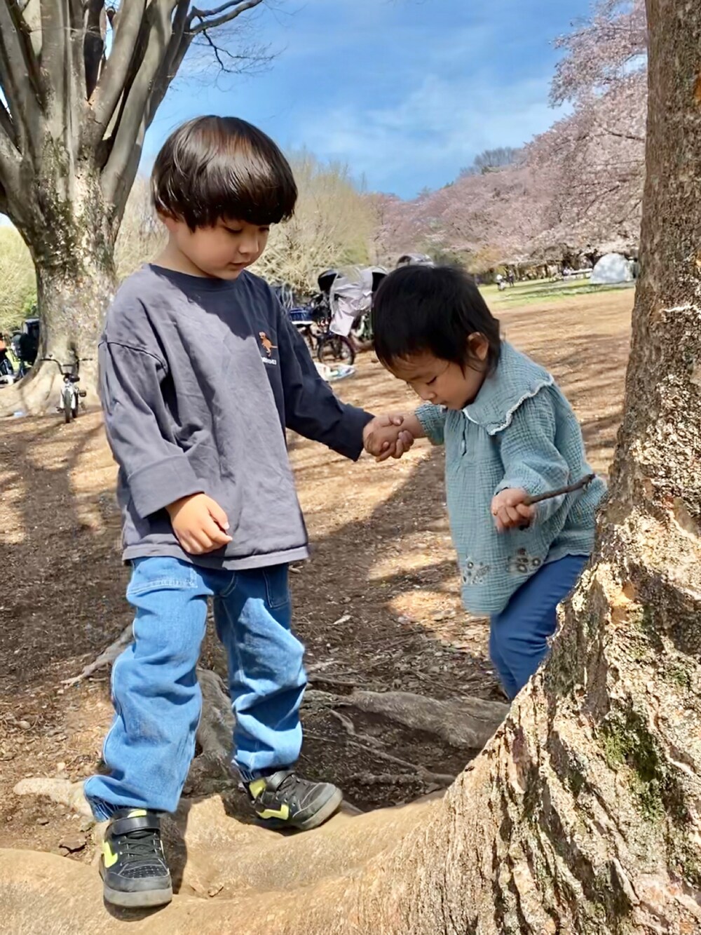 グレー系のTシャツ/カットソー、ブラック系のスニーカー、ブルー系のデニムパンツを着用したキッズの春コーディネートの3枚目の写真