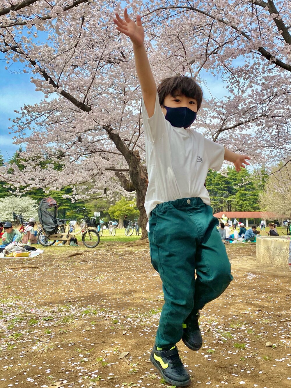 ホワイト系のTシャツ/カットソー、ベージュ系のその他パンツ、ブラック系のスニーカーを着用したキッズの春コーディネートの3枚目の写真