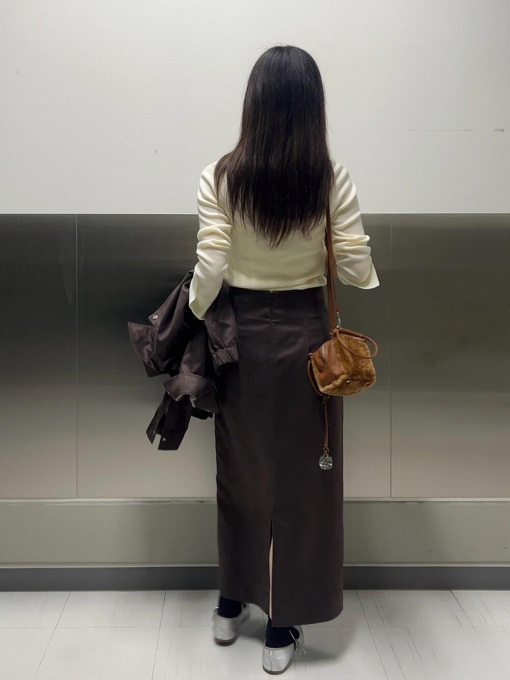 ブラウン系のブルゾン、ホワイト系のニット/セーター、ブラウン系のスカートを着用したレディースの秋コーディネートの9枚目の写真