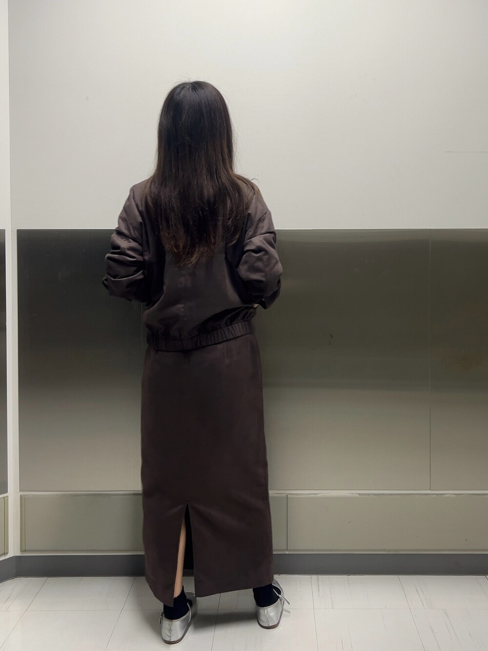 ブラウン系のブルゾン、ホワイト系のニット/セーター、ブラウン系のスカートを着用したレディースの秋コーディネートの4枚目の写真