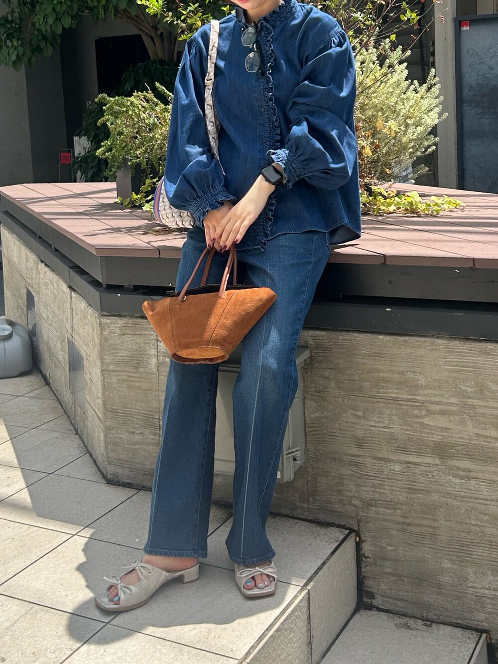 ブルー系のシャツ/ブラウス、ブルー系のデニムパンツ、パープル系のショルダーバッグを着用したレディースの夏コーディネートの3枚目の写真