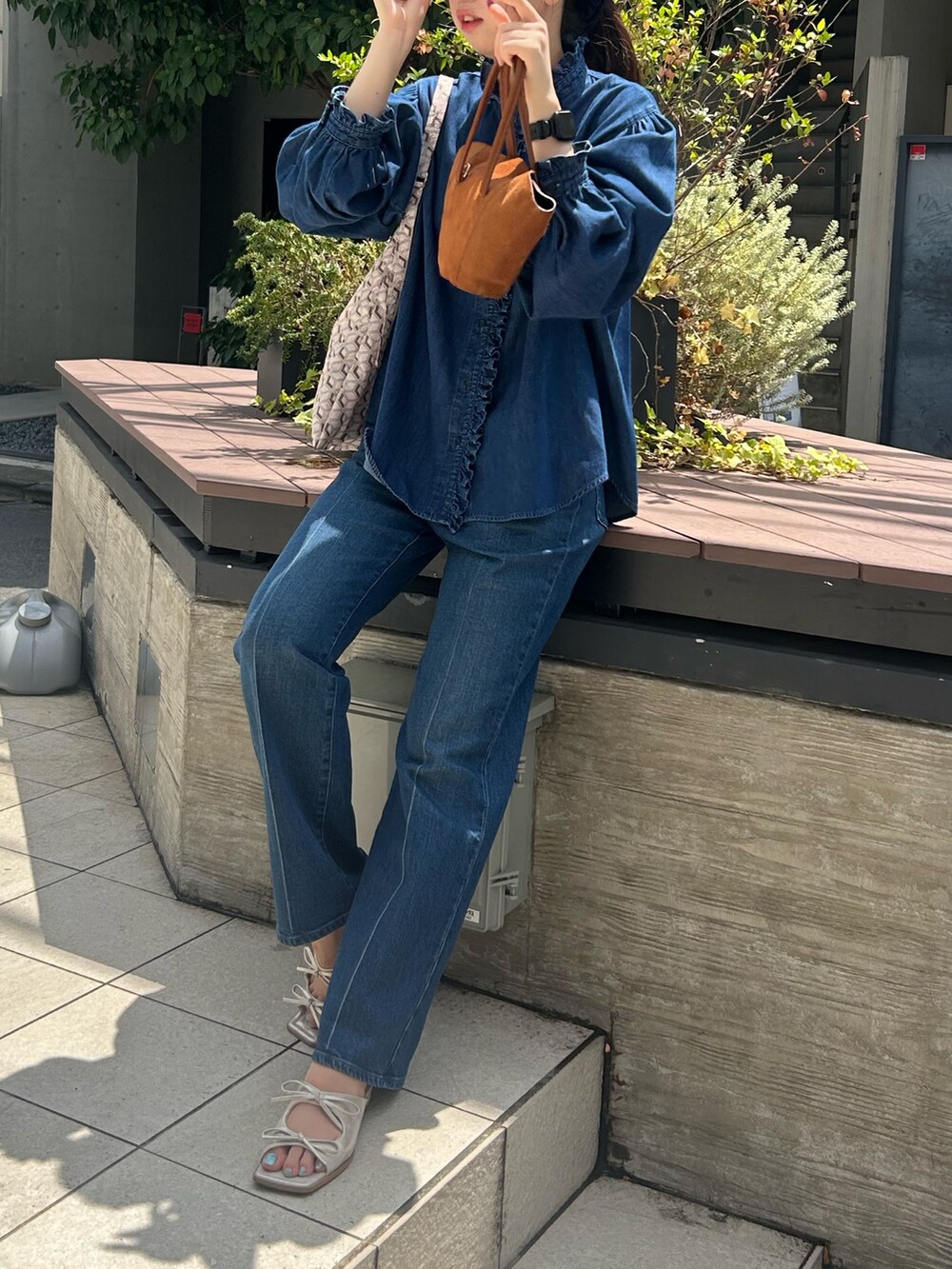 ブルー系のシャツ/ブラウス、ブルー系のデニムパンツ、パープル系のショルダーバッグを着用したレディースの夏コーディネートの4枚目の写真