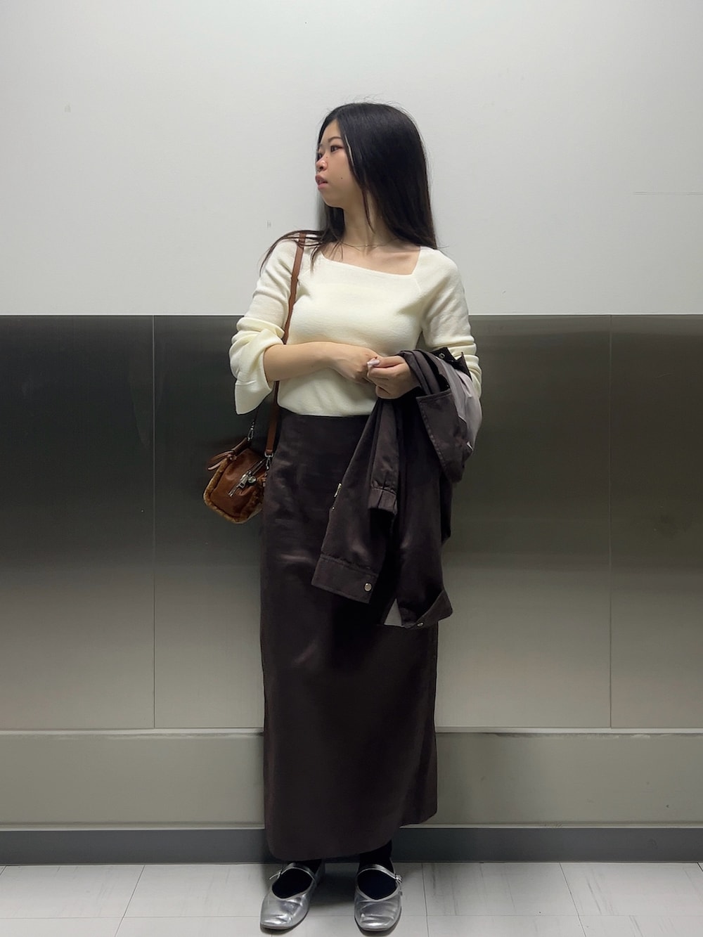 ブラウン系のブルゾン、ホワイト系のニット/セーター、ブラウン系のスカートを着用したレディースの秋コーディネートの7枚目の写真