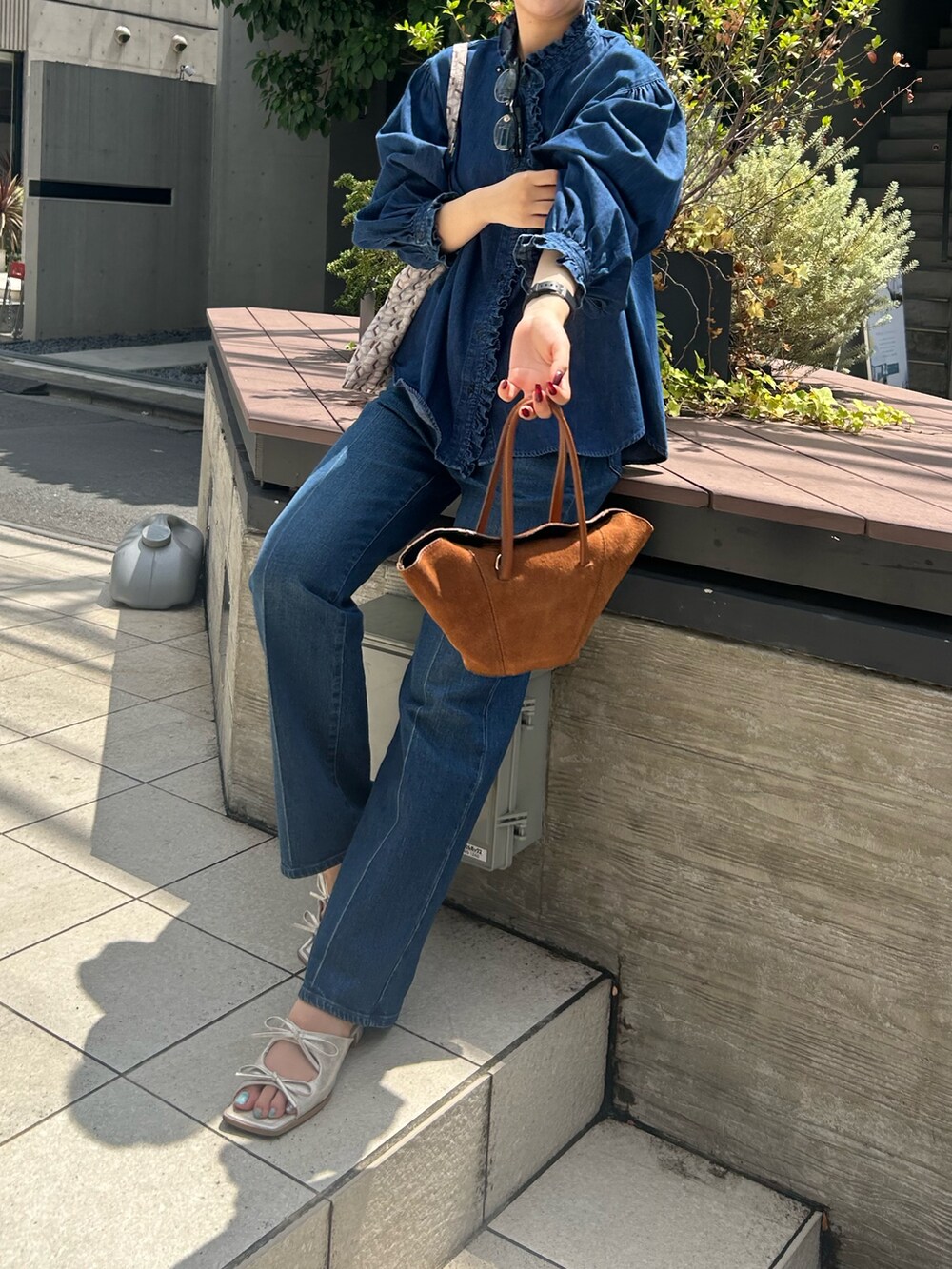 ブルー系のシャツ/ブラウス、ブルー系のデニムパンツ、パープル系のショルダーバッグを着用したレディースの夏コーディネートの2枚目の写真