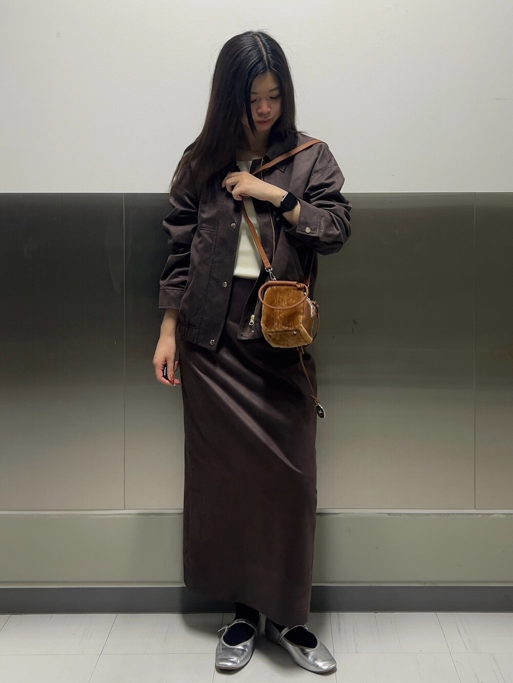 ブラウン系のブルゾン、ホワイト系のニット/セーター、ブラウン系のスカートを着用したレディースの秋コーディネートの2枚目の写真