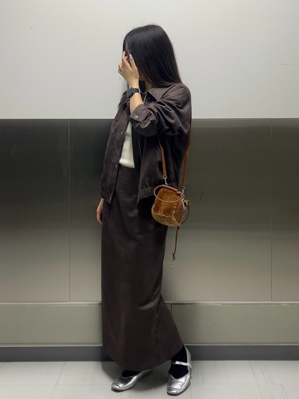 ブラウン系のブルゾン、ホワイト系のニット/セーター、ブラウン系のスカートを着用したレディースの秋コーディネートの3枚目の写真