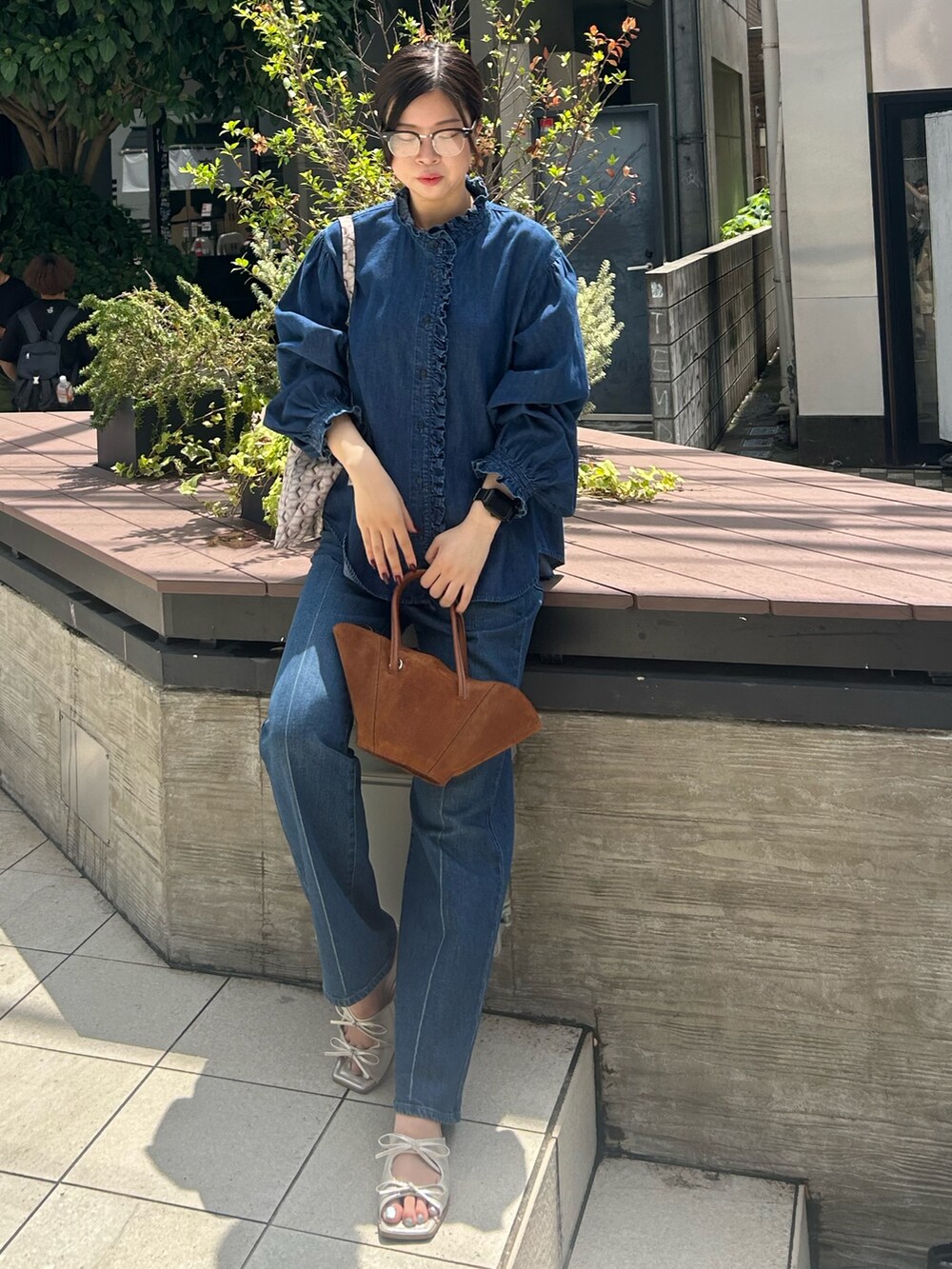 ブルー系のシャツ/ブラウス、ブルー系のデニムパンツ、パープル系のショルダーバッグを着用したレディースの夏コーディネートの5枚目の写真