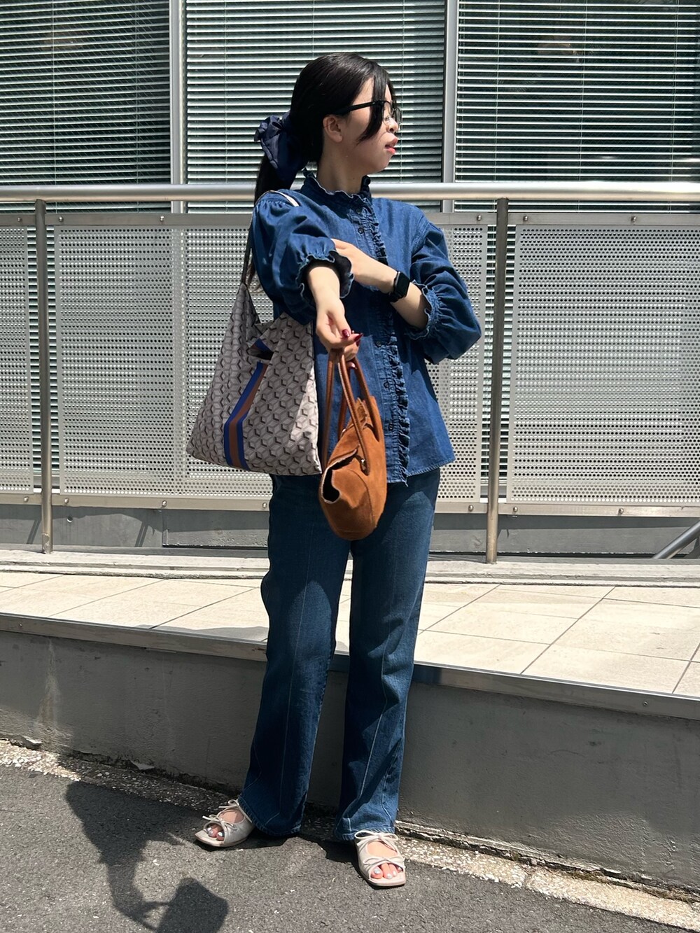 ブルー系のシャツ/ブラウス、ブルー系のデニムパンツ、パープル系のショルダーバッグを着用したレディースの夏コーディネートの7枚目の写真