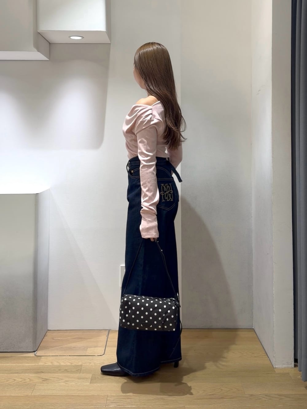 ピンク系のニット/セーター、ブルー系のデニムパンツ、ブラック系のブーツを着用したレディースの秋コーディネートの4枚目の写真