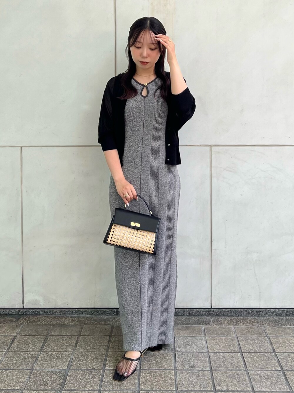 ブラック系のカーディガン/ボレロ、グレー系のワンピース、ブラック系のハンドバッグを着用したレディースの夏コーディネートの2枚目の写真