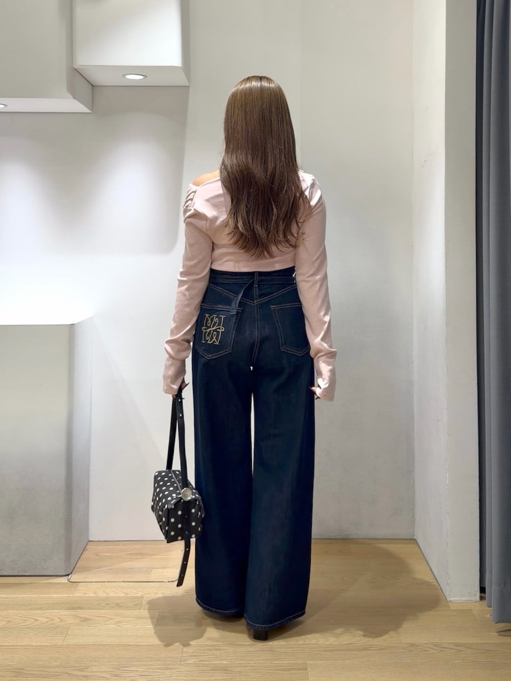 ピンク系のニット/セーター、ブルー系のデニムパンツ、ブラック系のブーツを着用したレディースの秋コーディネートの3枚目の写真