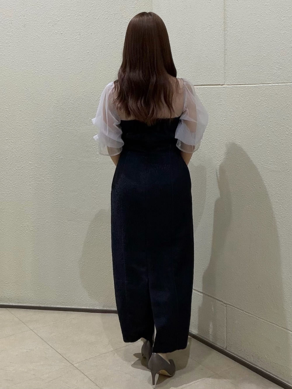 ブルー系のドレス、シルバー系のクラッチバッグ、シルバー系のパンプスを着用したレディースの春コーディネートの3枚目の写真