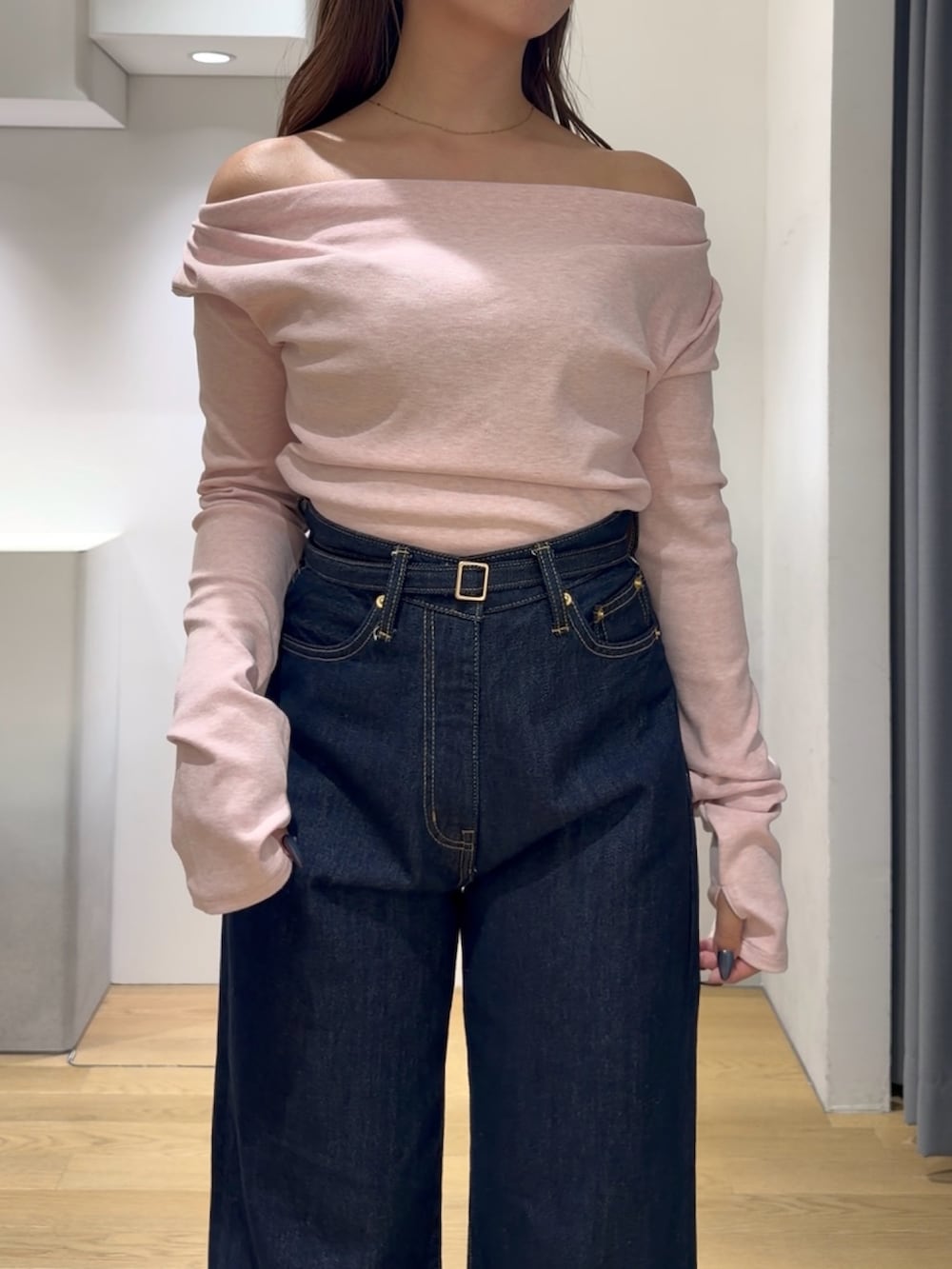 ピンク系のニット/セーター、ブルー系のデニムパンツ、ブラック系のブーツを着用したレディースの秋コーディネートの6枚目の写真