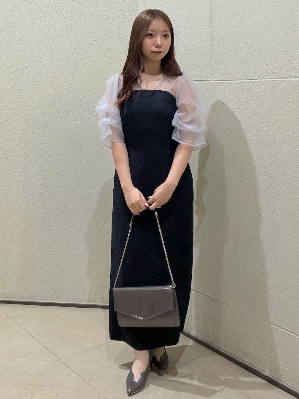 ブルー系のドレス、シルバー系のクラッチバッグ、シルバー系のパンプスを着用したレディースの春コーディネートの2枚目の写真