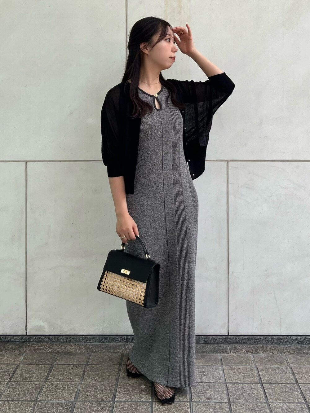ブラック系のカーディガン/ボレロ、グレー系のワンピース、ブラック系のハンドバッグを着用したレディースの夏コーディネートの3枚目の写真