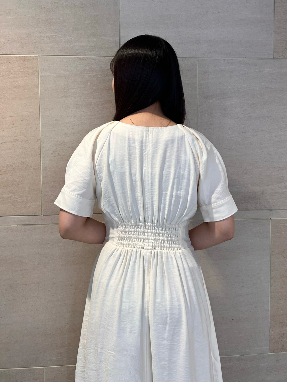 ホワイト系のワンピース、ホワイト系のサンダルを着用したレディースの春コーディネートの6枚目の写真