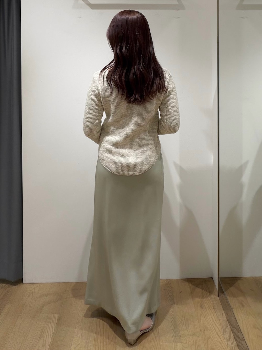 ベージュ系のニット/セーター、グリーン系のスカート、シルバー系のパンプスを着用したレディースの冬コーディネートの4枚目の写真