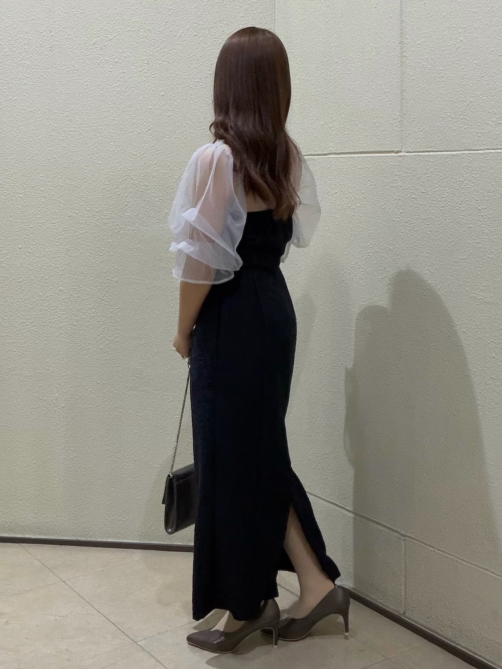 ブルー系のドレス、シルバー系のクラッチバッグ、シルバー系のパンプスを着用したレディースの春コーディネートの4枚目の写真