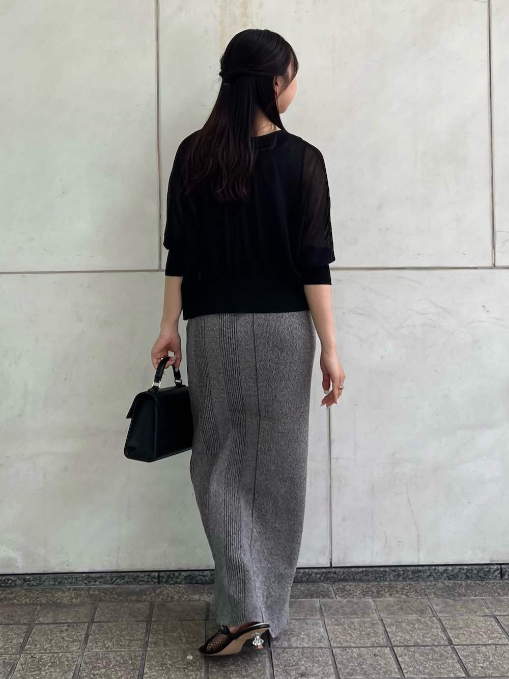 ブラック系のカーディガン/ボレロ、グレー系のワンピース、ブラック系のハンドバッグを着用したレディースの夏コーディネートの5枚目の写真