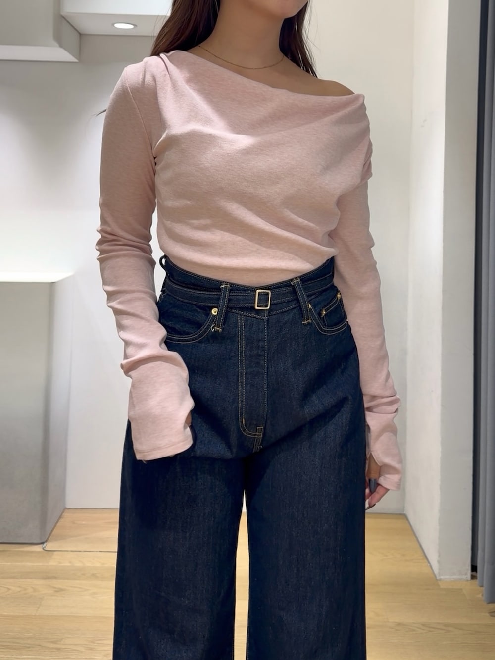 ピンク系のニット/セーター、ブルー系のデニムパンツ、ブラック系のブーツを着用したレディースの秋コーディネートの5枚目の写真