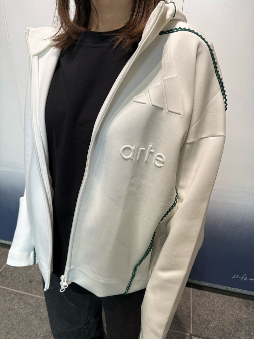 ホワイト系のトップス、ブラック系のトップス、ホワイト系のスニーカーを着用したレディースの冬コーディネートの2枚目の写真