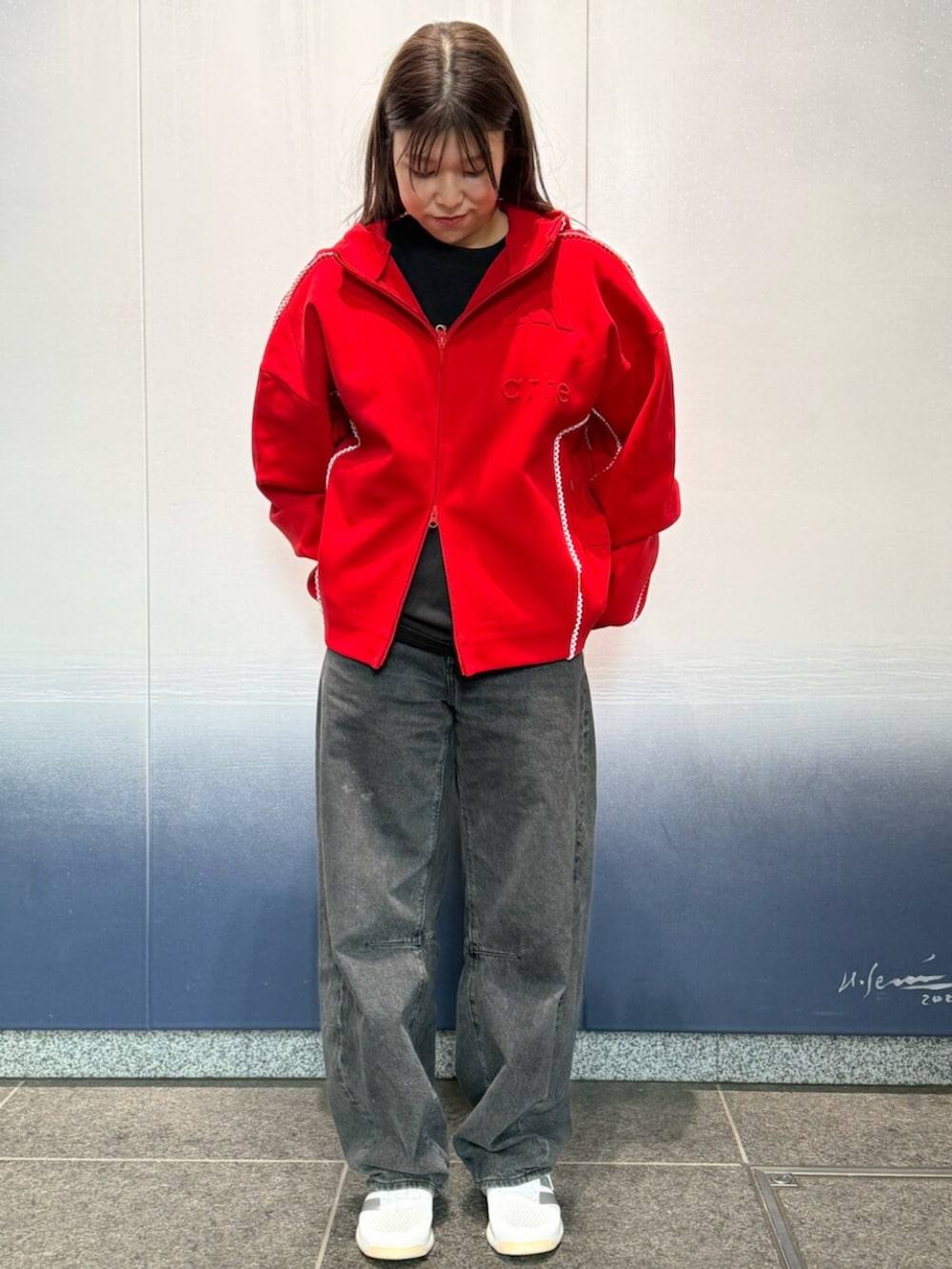 ホワイト系のスニーカー、レッド系のトップスを着用したレディースの冬コーディネートの2枚目の写真