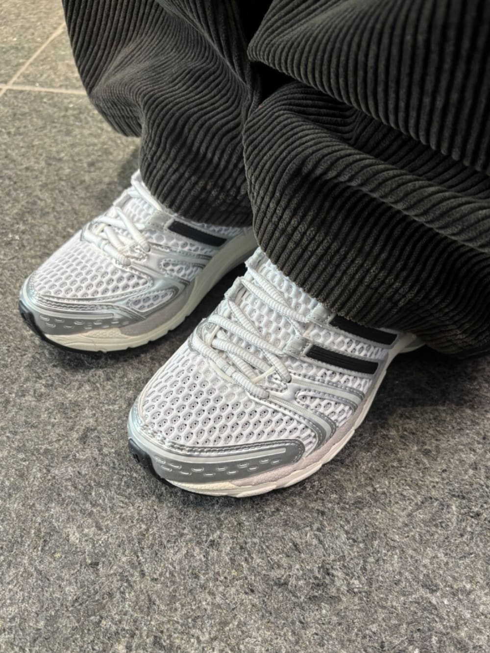 ベージュ系のその他アウター、ブラック系のスウェットパンツ、シルバー系のスニーカーを着用したレディースの冬コーディネートの2枚目の写真