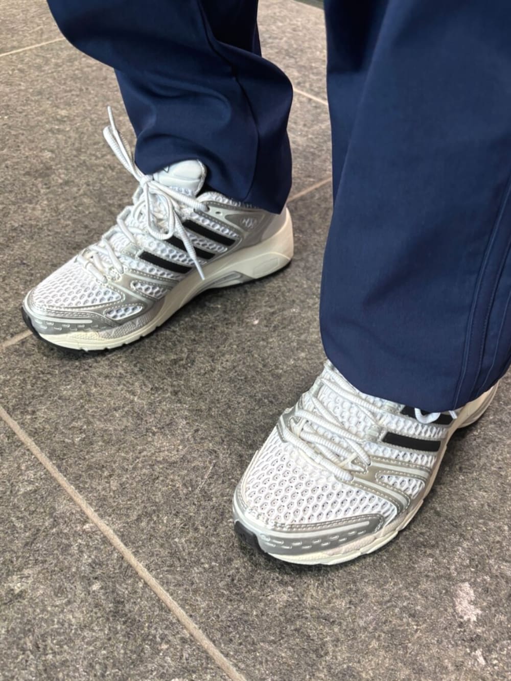 イエロー系のニット/セーター、ブルー系のその他パンツ、シルバー系のスニーカーを着用したレディースの冬コーディネートの2枚目の写真