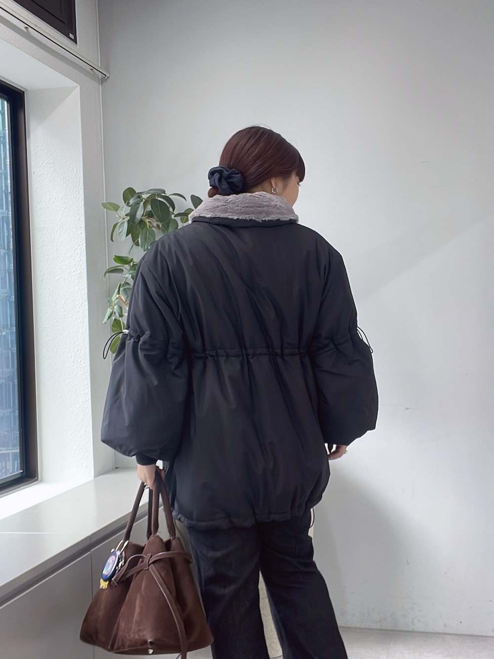 ブラック系のその他アウター、ブルー系のデニムパンツを着用したレディースの秋コーディネートの2枚目の写真