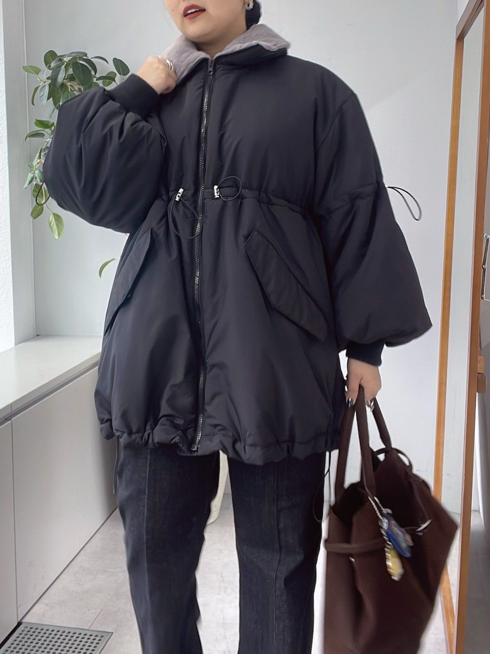 ブラック系のその他アウター、ブルー系のデニムパンツを着用したレディースの秋コーディネートの3枚目の写真