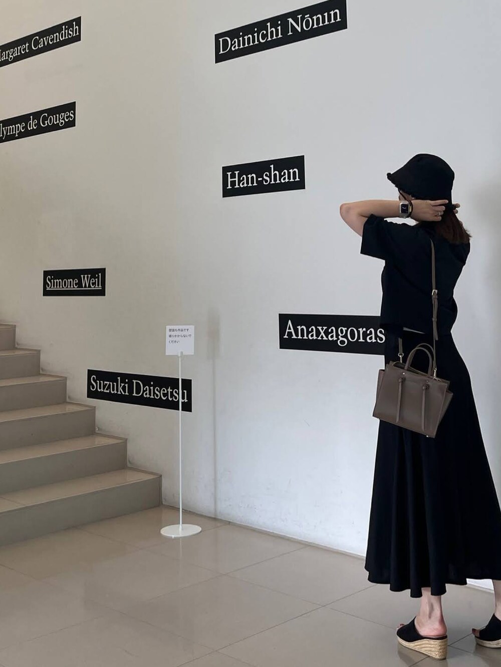 ブラック系のシャツ/ブラウス、グレー系のショルダーバッグ、ブラック系のスカートを着用したレディースの秋コーディネートの2枚目の写真