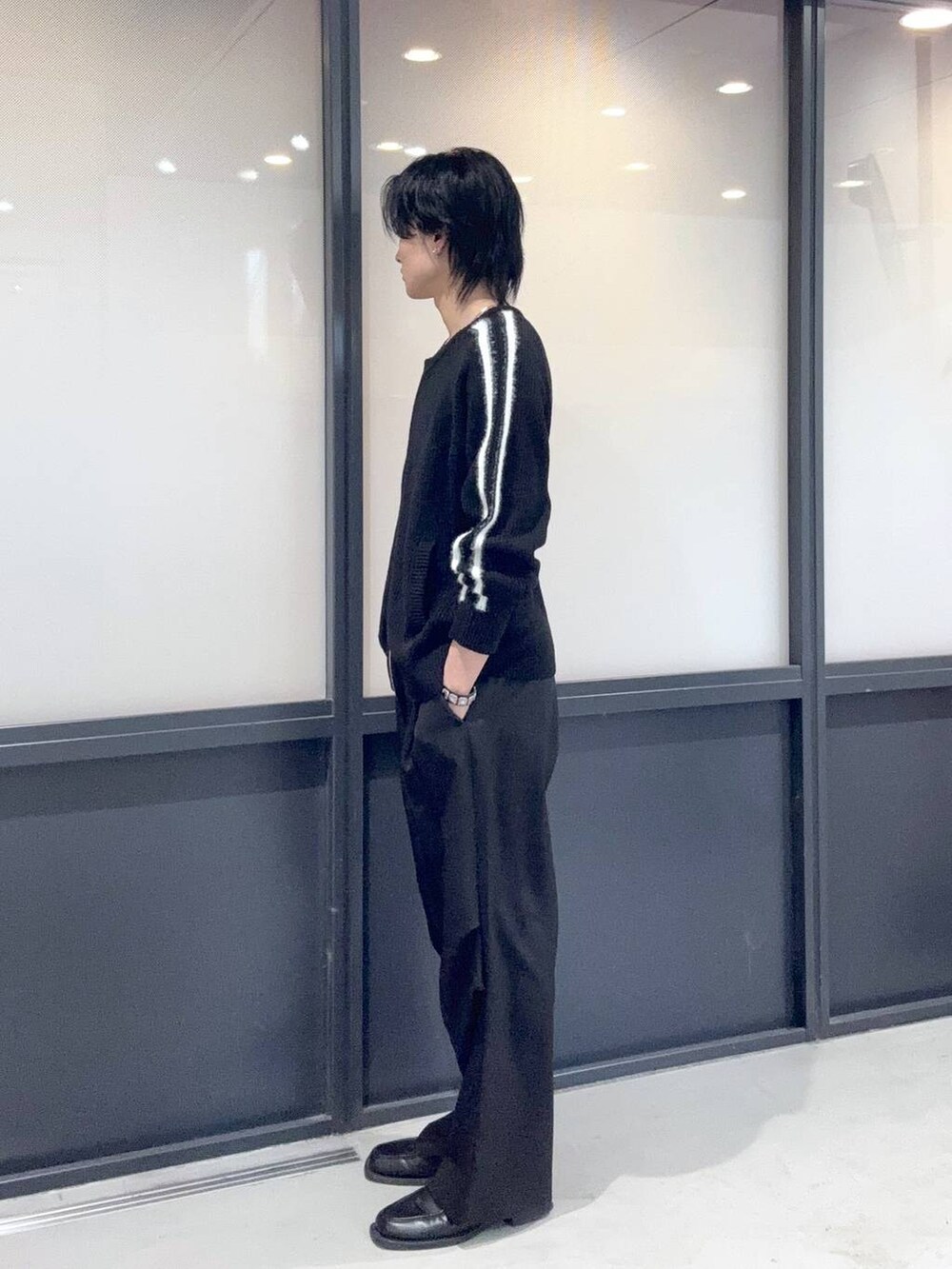 ブラック系のニット/セーター、ブラック系のスラックスを着用したメンズの冬コーディネートの2枚目の写真