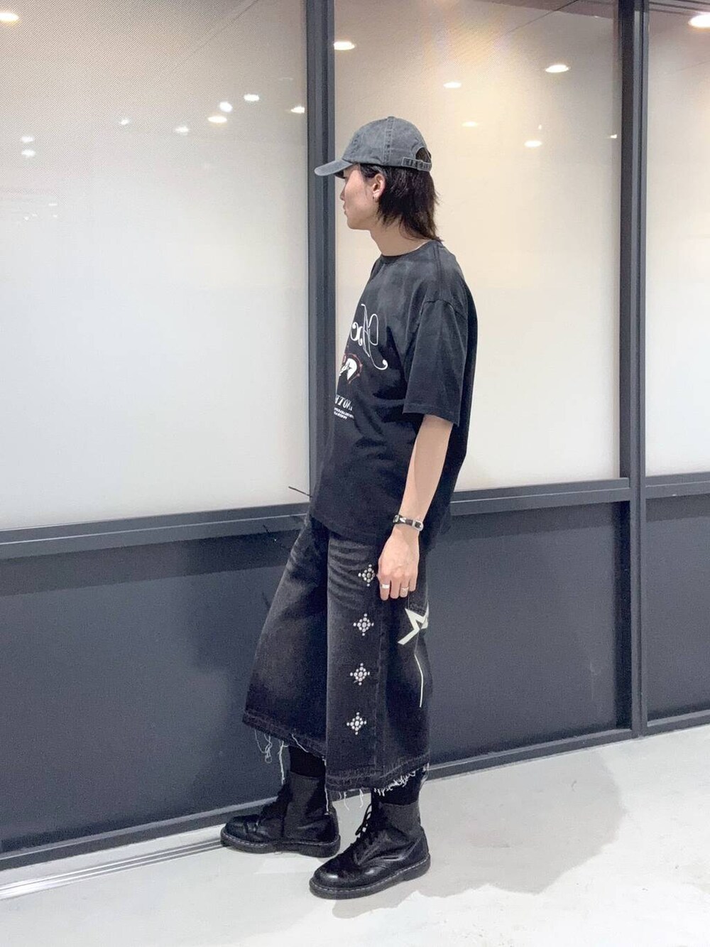 ブラック系のデニムパンツ、ブラック系のTシャツ/カットソー、ブラック系のキャップを着用したメンズの春コーディネートの2枚目の写真