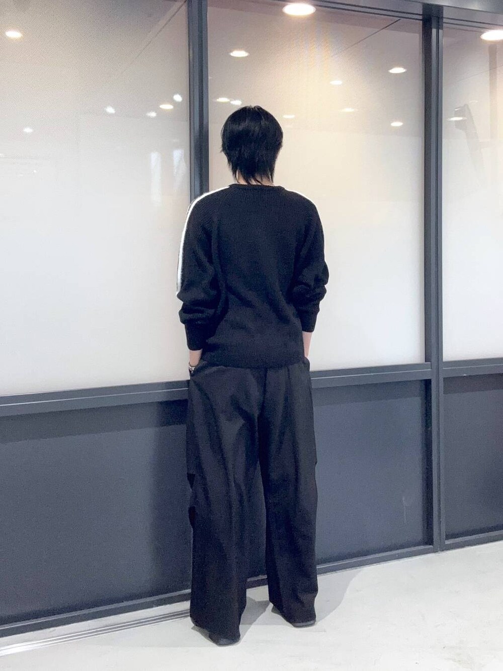 ブラック系のニット/セーター、ブラック系のスラックスを着用したメンズの冬コーディネートの3枚目の写真