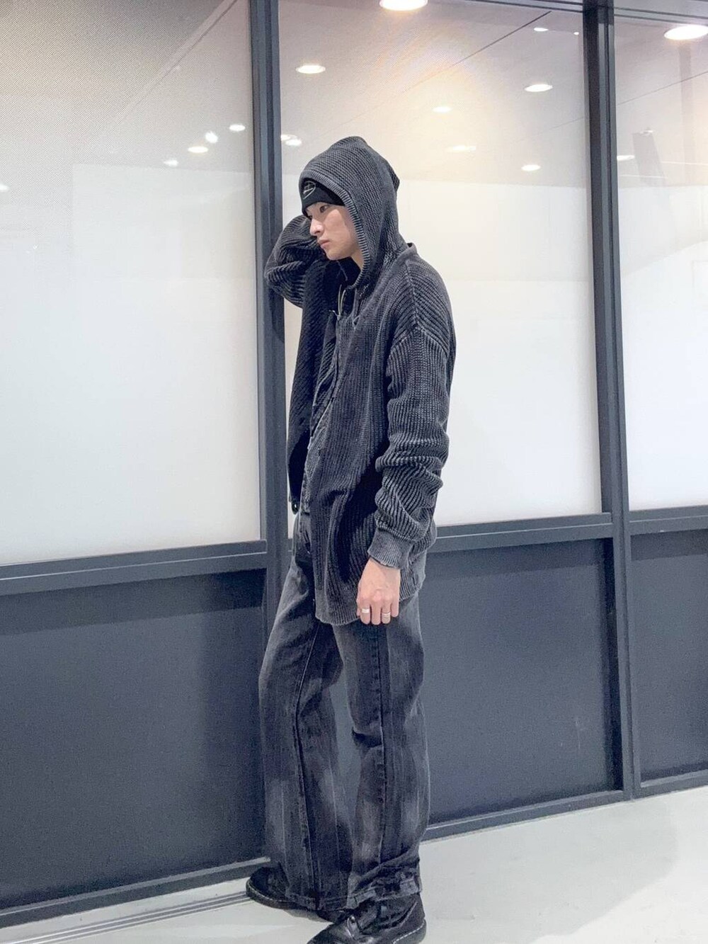 ブラック系のニット/セーター、ブラック系のパーカー、ブラック系のデニムパンツを着用したメンズの冬コーディネートの2枚目の写真