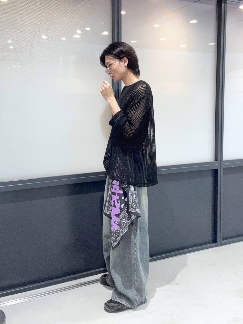 ブルー系のデニムパンツ、ブラック系のニット/セーター、グレー系のストール/ショールを着用したメンズの夏コーディネートの2枚目の写真