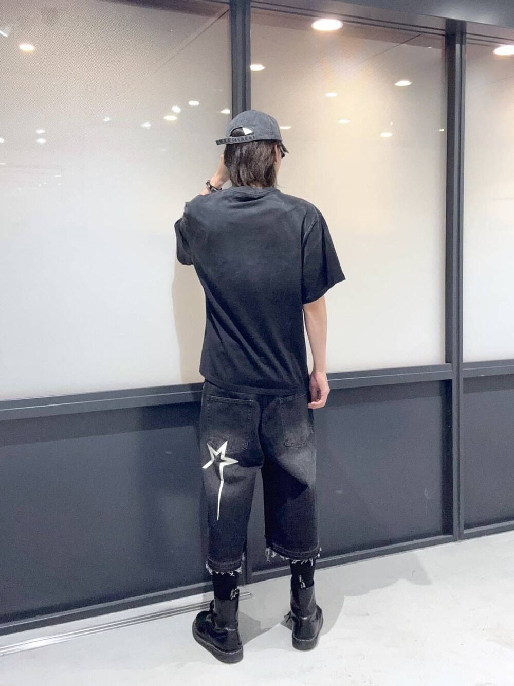 ブラック系のデニムパンツ、ブラック系のTシャツ/カットソー、ブラック系のキャップを着用したメンズの春コーディネートの3枚目の写真