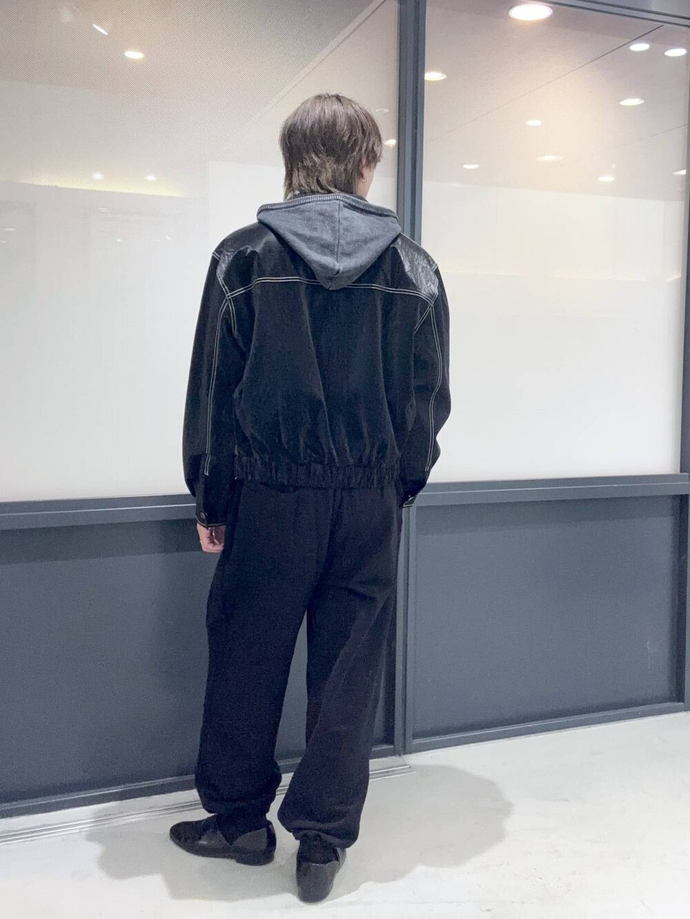 ブラック系のパーカー、ブラック系のスウェットパンツを着用したメンズの春コーディネートの3枚目の写真
