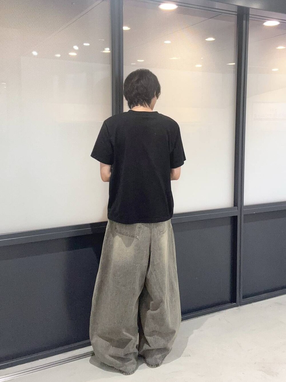 ブラック系のTシャツ/カットソー、ブラック系のデニムパンツを着用したメンズの夏コーディネートの3枚目の写真