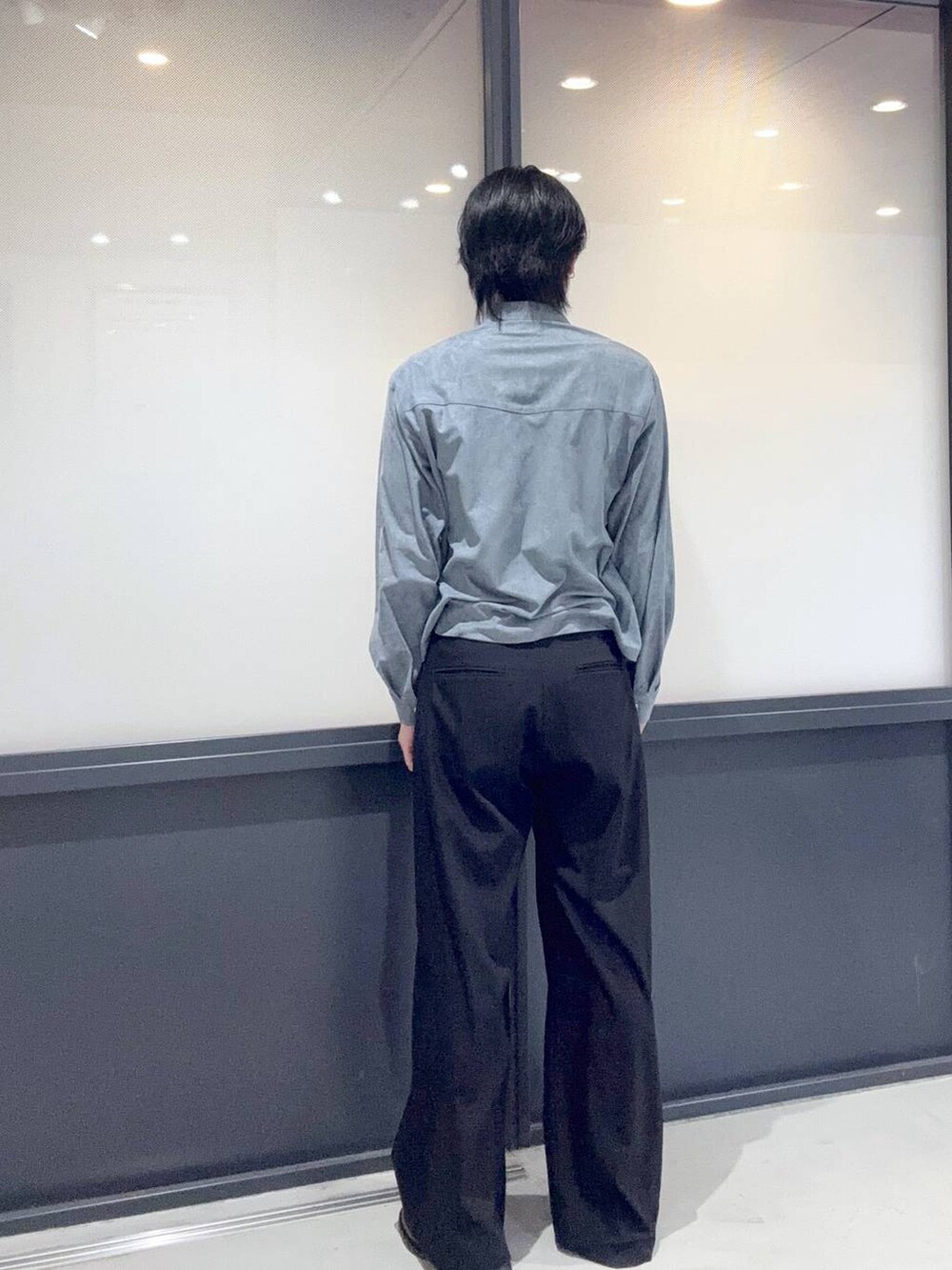 ブラック系のスラックス、ブルー系のシャツ/ブラウスを着用したメンズの冬コーディネートの3枚目の写真