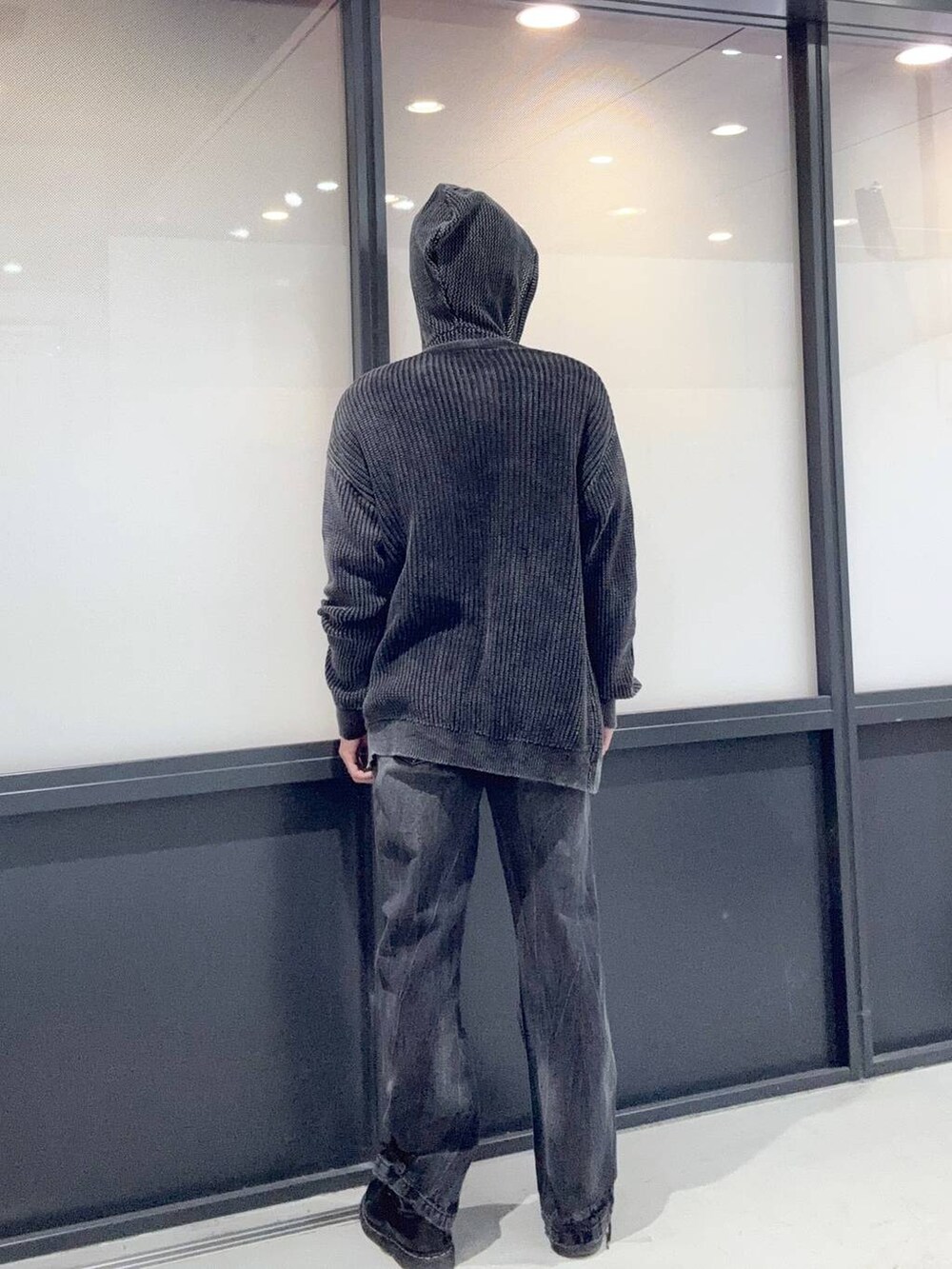 ブラック系のニット/セーター、ブラック系のパーカー、ブラック系のデニムパンツを着用したメンズの冬コーディネートの3枚目の写真