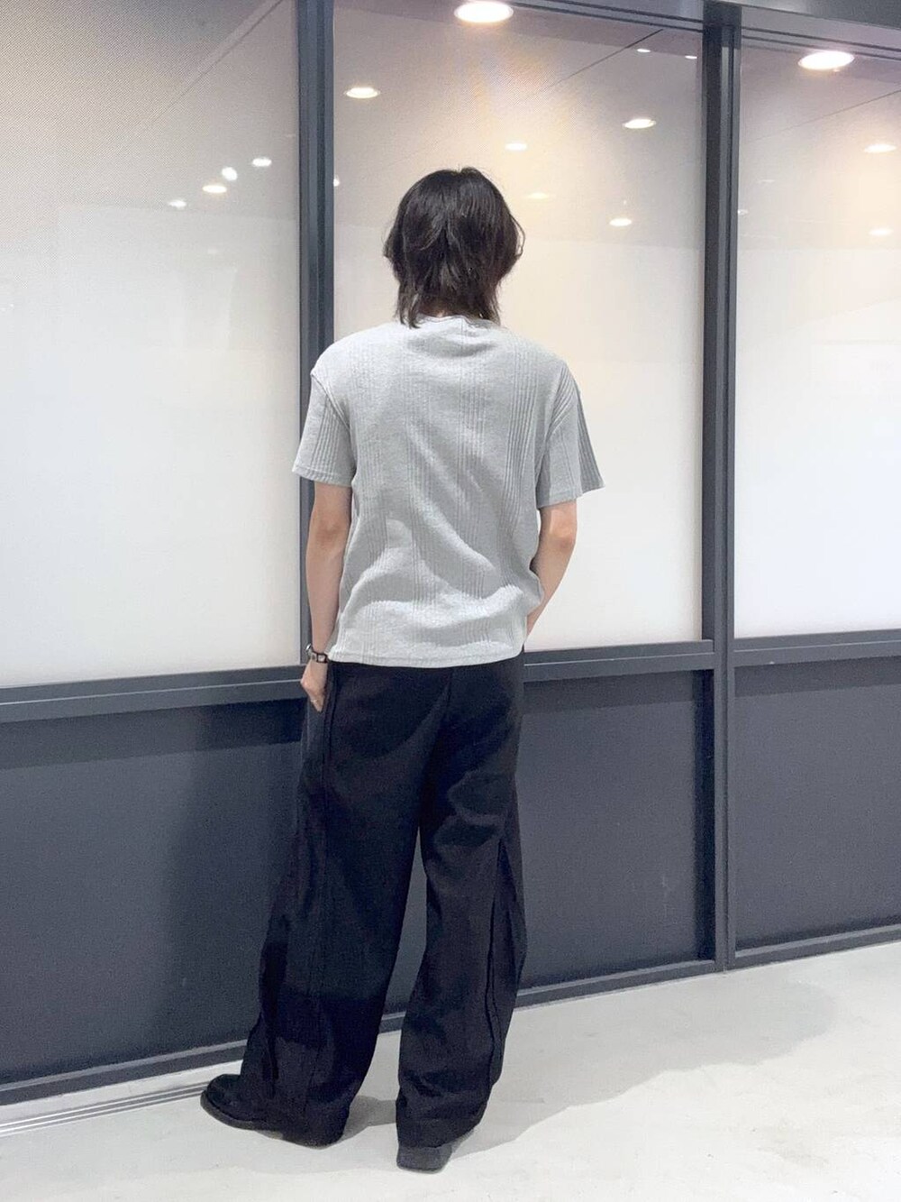 ブラック系のスラックスを着用したメンズの夏コーディネートの3枚目の写真