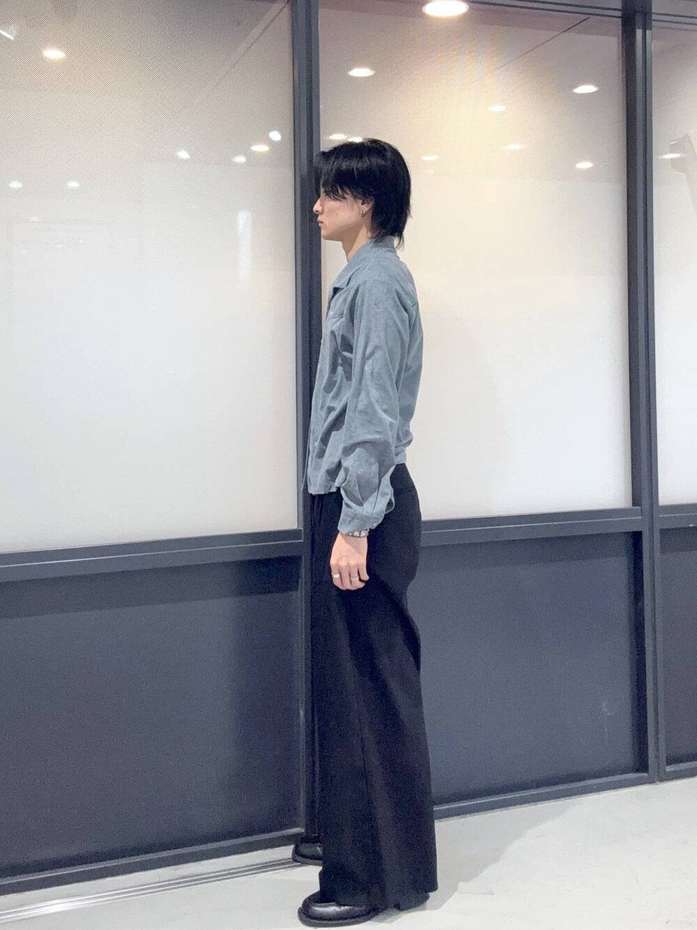 ブラック系のスラックス、ブルー系のシャツ/ブラウスを着用したメンズの冬コーディネートの2枚目の写真