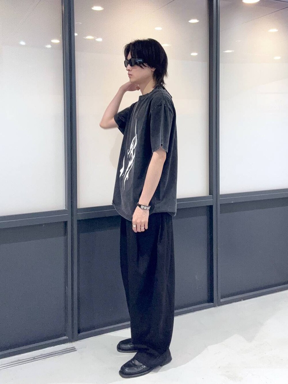 ブラック系のTシャツ/カットソーを着用したメンズの春コーディネートの2枚目の写真