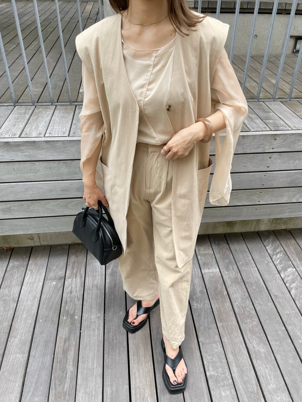 ベージュ系のトップス、ベージュ系のその他パンツ、ベージュ系のベストを着用したレディースの夏コーディネートの4枚目の写真