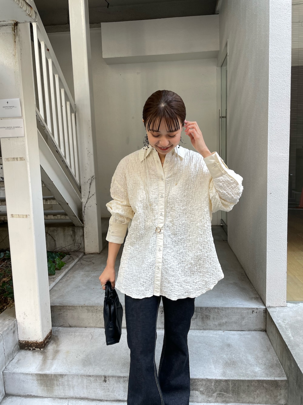 ブラック系のデニムパンツ、ホワイト系のシャツ/ブラウスを着用したレディースの冬コーディネートの4枚目の写真