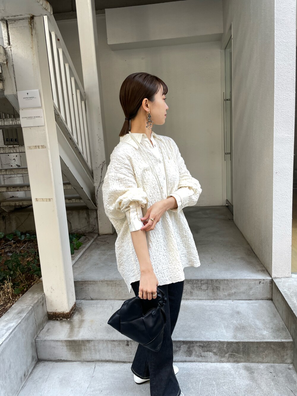 ブラック系のデニムパンツ、ホワイト系のシャツ/ブラウスを着用したレディースの冬コーディネートの3枚目の写真