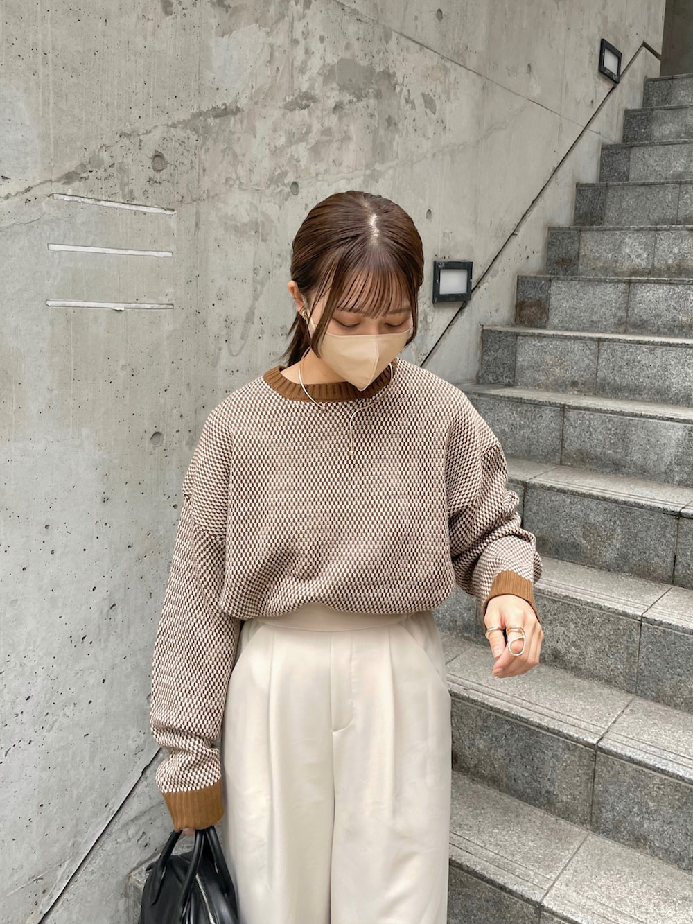 ブラウン系のニット/セーター、ホワイト系のパンツ、ゴールド系のネックレスを着用したレディースの秋コーディネートの2枚目の写真