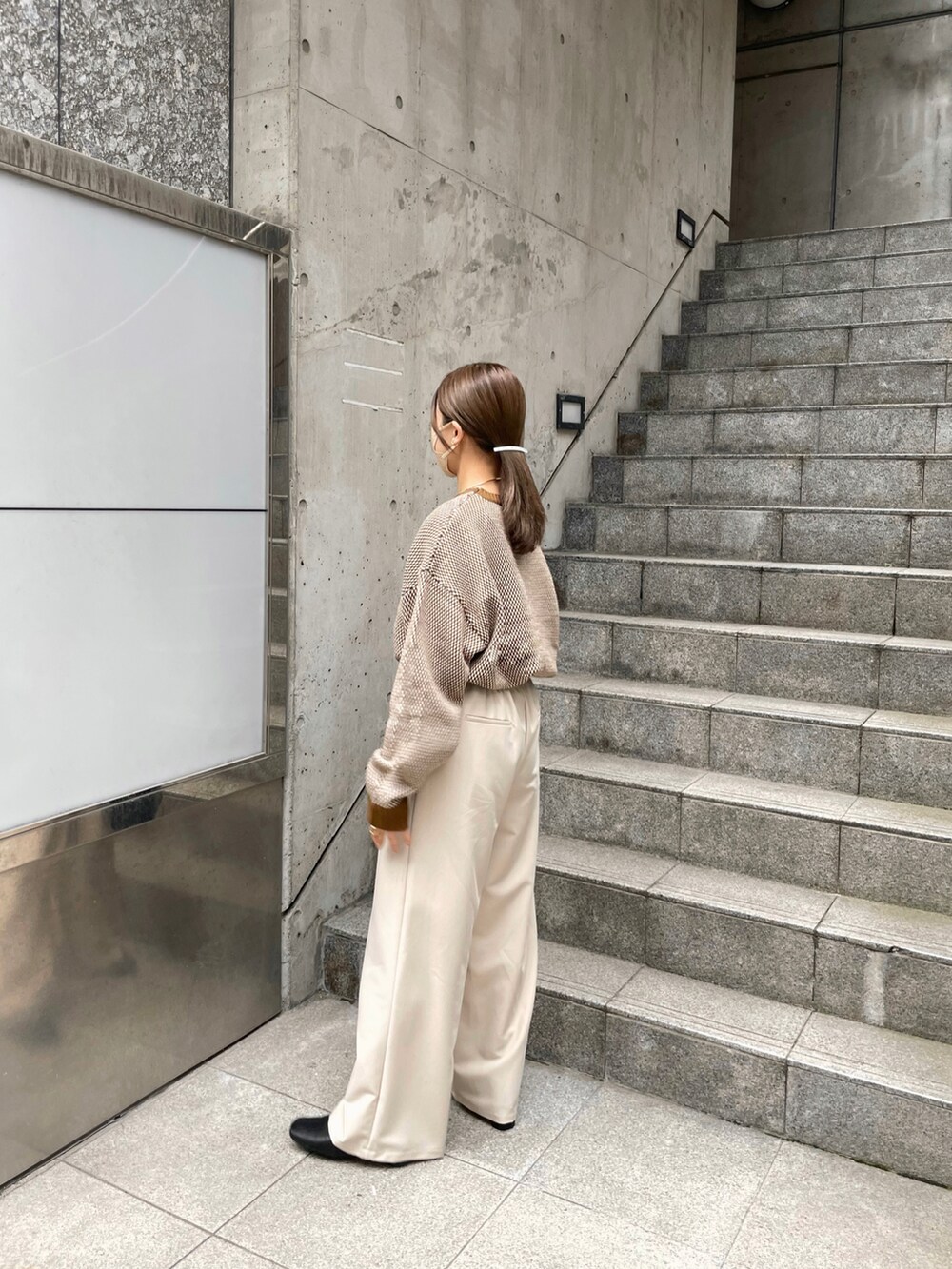 ブラウン系のニット/セーター、ホワイト系のパンツ、ゴールド系のネックレスを着用したレディースの秋コーディネートの4枚目の写真