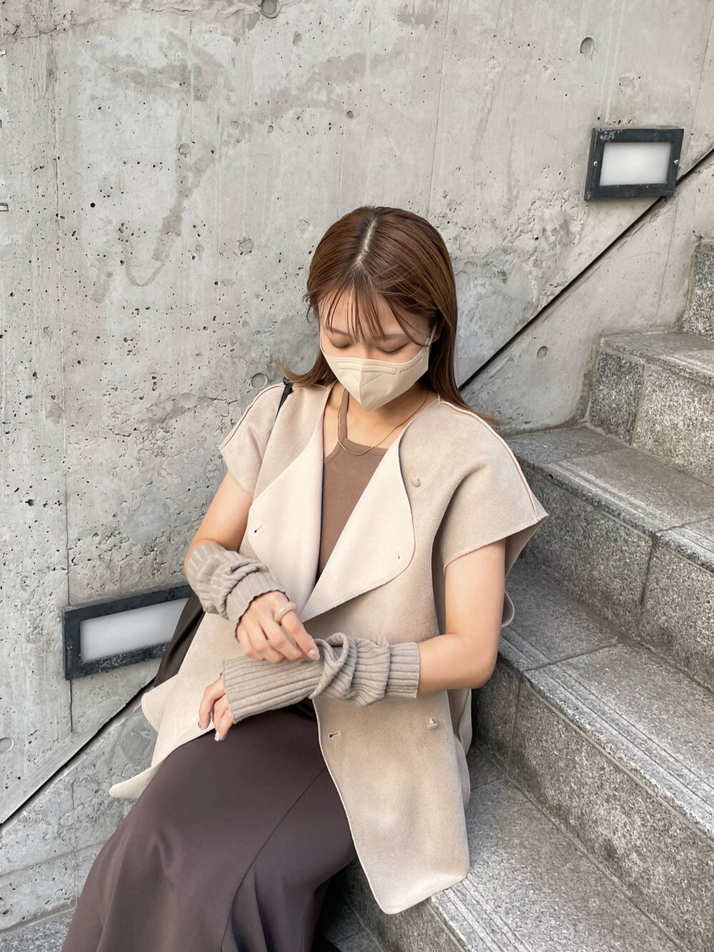 ブラウン系のブーツ、ベージュ系のベスト、ブラウン系のスカートを着用したレディースの秋コーディネートの4枚目の写真